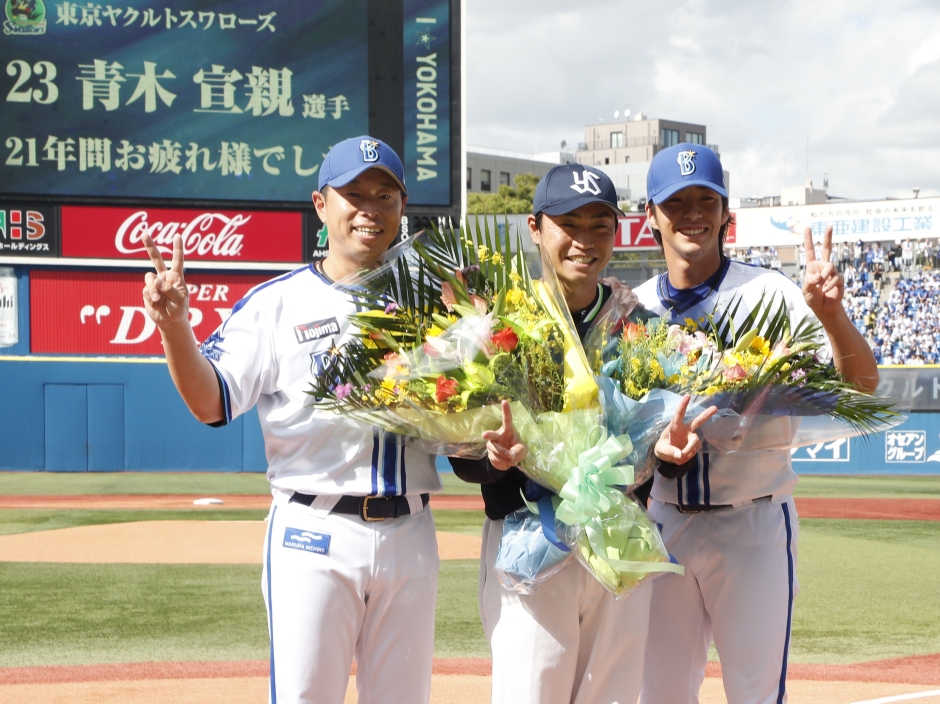 試合前、DeNAの田中コーチ（左）から花束を贈られた青木選手（共同通信）