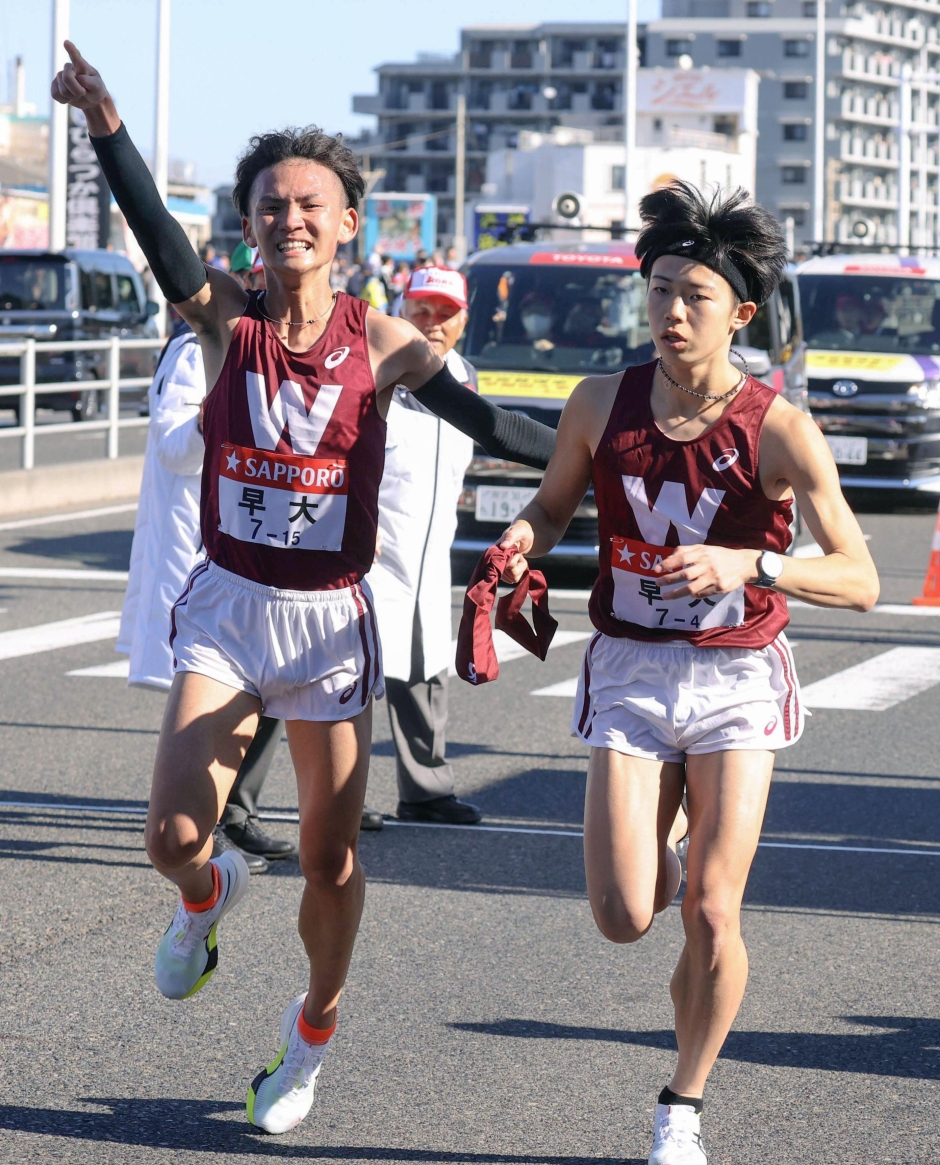平塚中継所でたすきをつなぐ3区・山口竣平(左)と4区・長屋匡起。共にアシックスメタスピードで箱根路を駆け抜けた(共同通信)