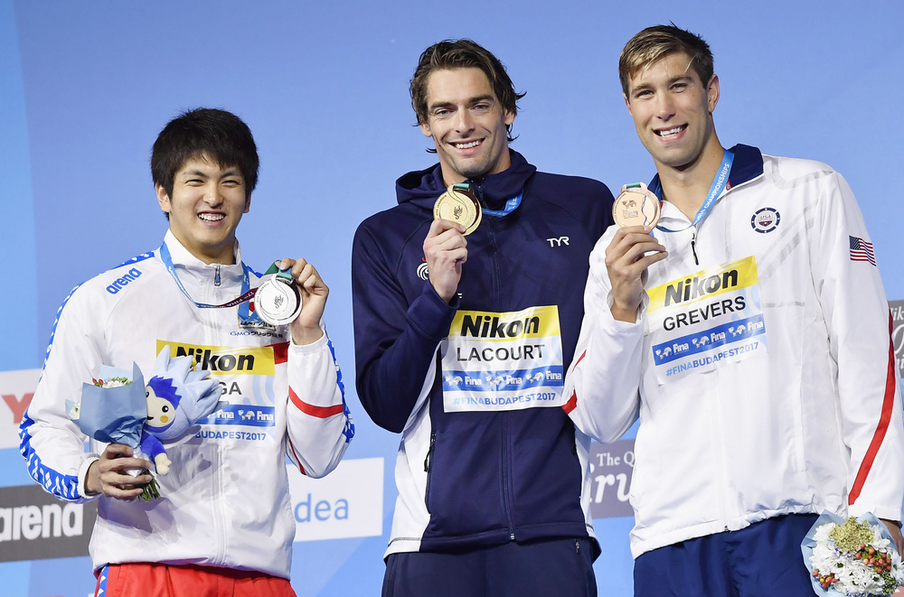 男子５０m背泳ぎで銀メダルに輝き、表彰台で記念写真に納まる古賀淳也選手（左）（共同）