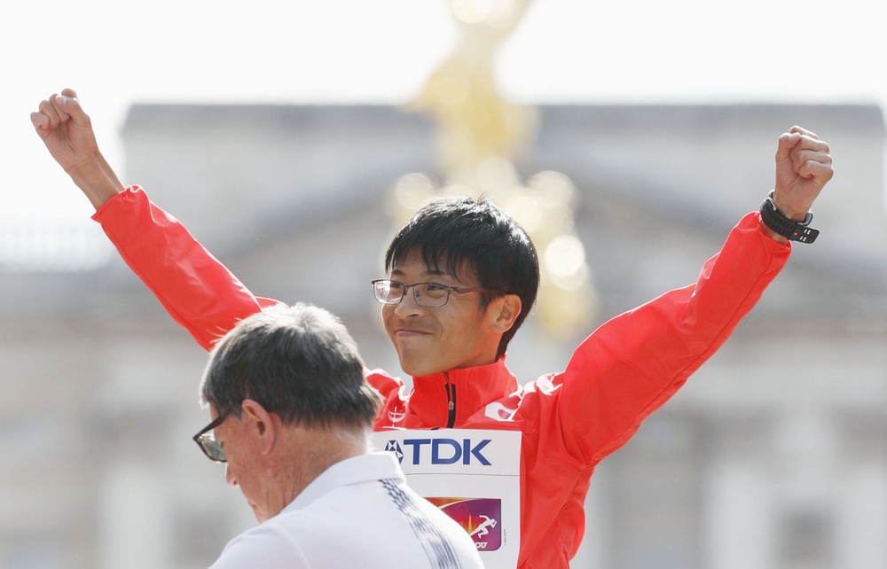 男子50キロ競歩の表彰式で声援に応える銅メダルの小林快選手=ロンドン(共同)