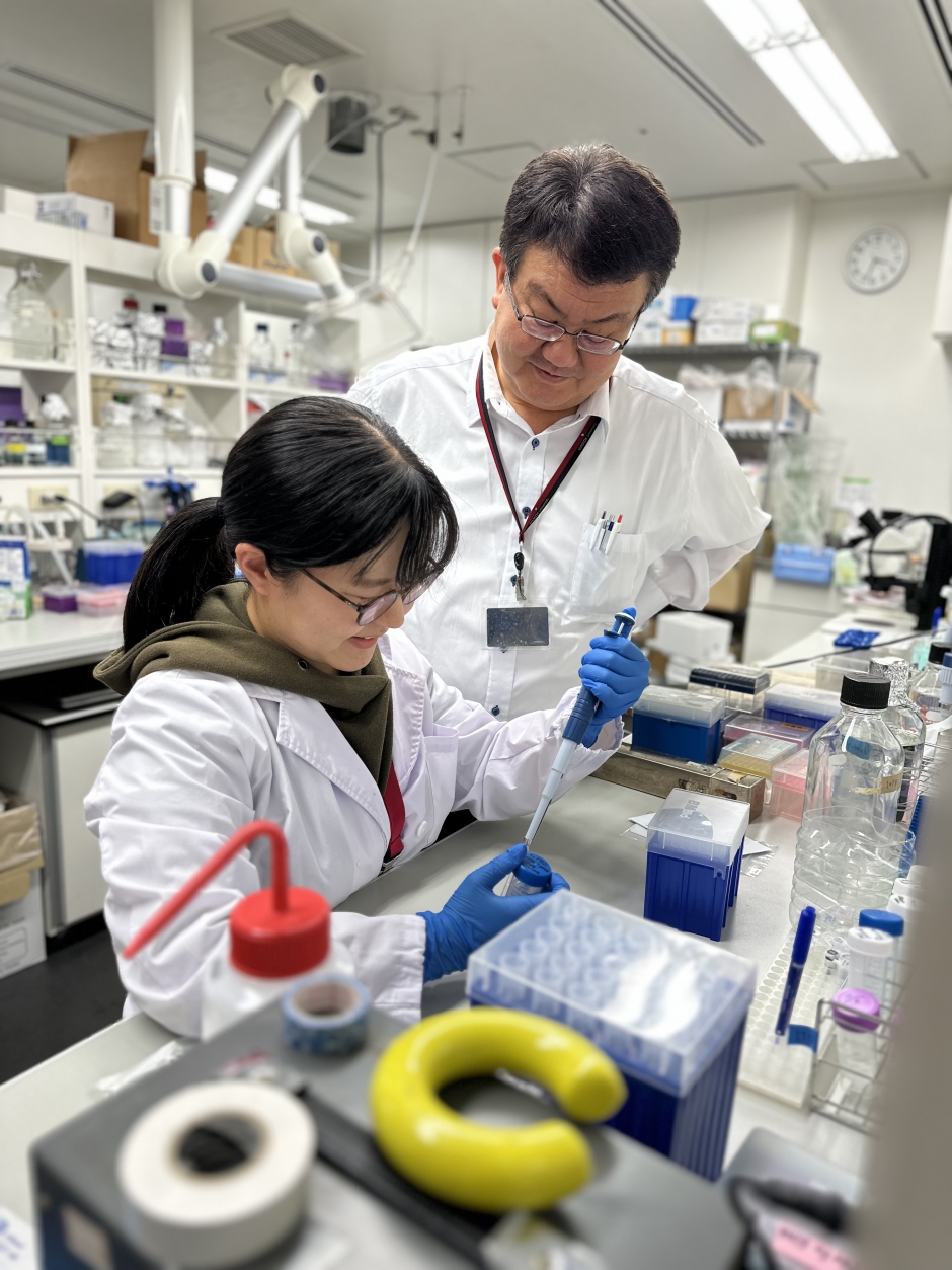 伊藤悦朗教授の指導のもと、実験をする佐藤さん