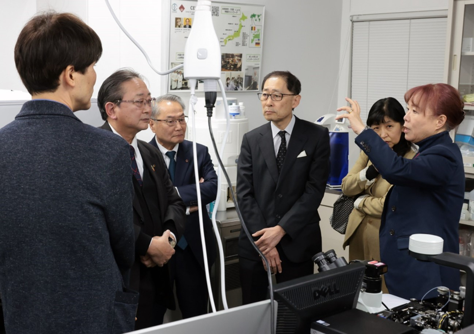ラボツアーに参加された企業経営者の校友の皆様に説明を行う竹山春子教授（右端）