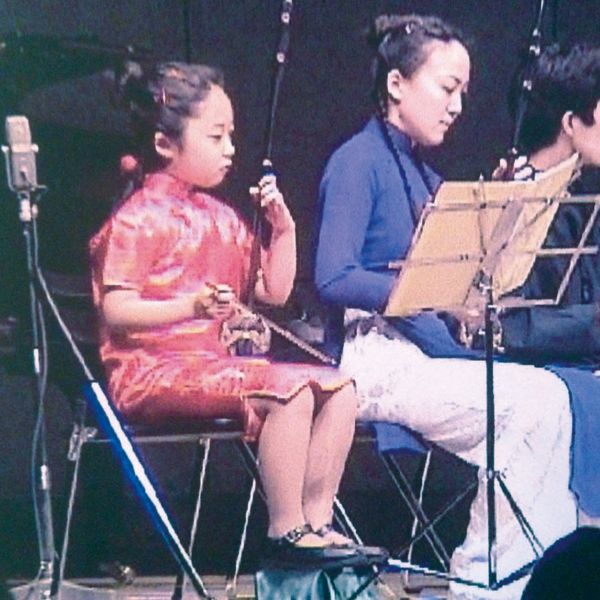 Nakanishi at the age of six, when she had just begun playing the erhu. She is playing in a concert together with adults.
