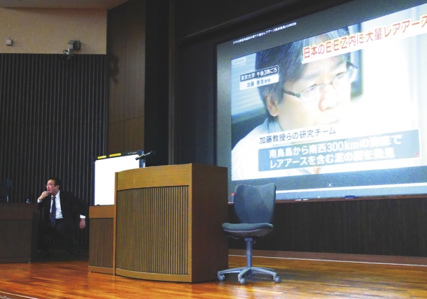 Professor Banzai explains material while students are watching a news video in class.