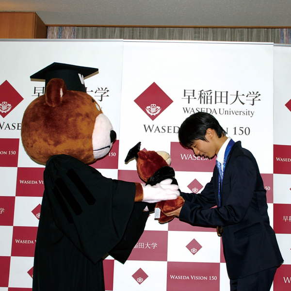 Hanyu was handed a stuffed likeness from the Waseda Bear at a report meeting.