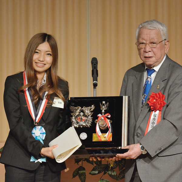 Ishikawa placed second in the university student division of the 43rd Mayor of Honolulu All Japan Youth English Oratorical Contest; here she is being presented with a plaque by the chief contest judge.