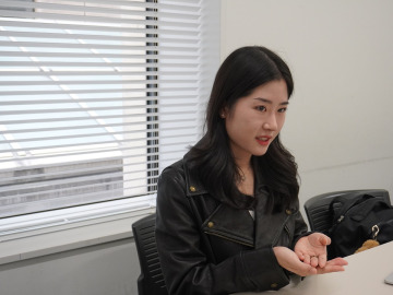 11 号館で取材に応じるコウさん