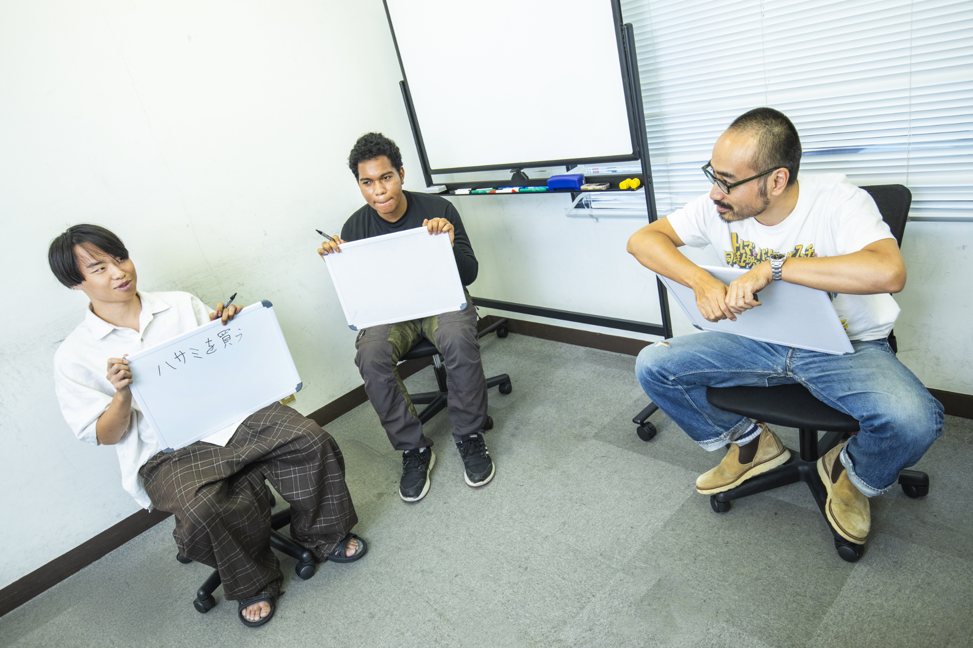 泉水太陽さんが回答を手に持ち,、二人がそれを見る写真