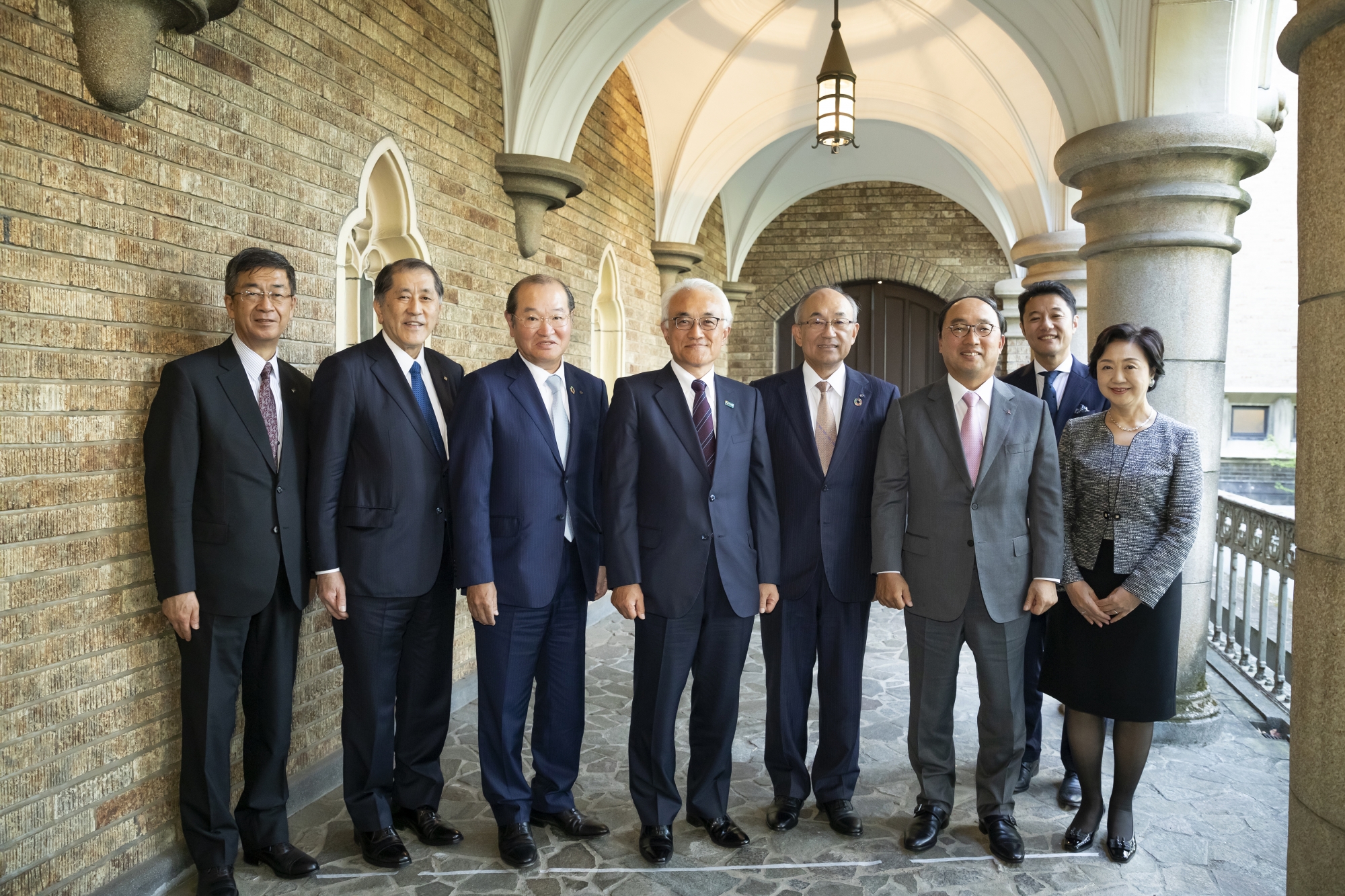 回廊での記念写真。左から須賀副総長、田中総長、中田氏、根岸氏、井上氏、漆間氏、入山教授、齋藤副総長