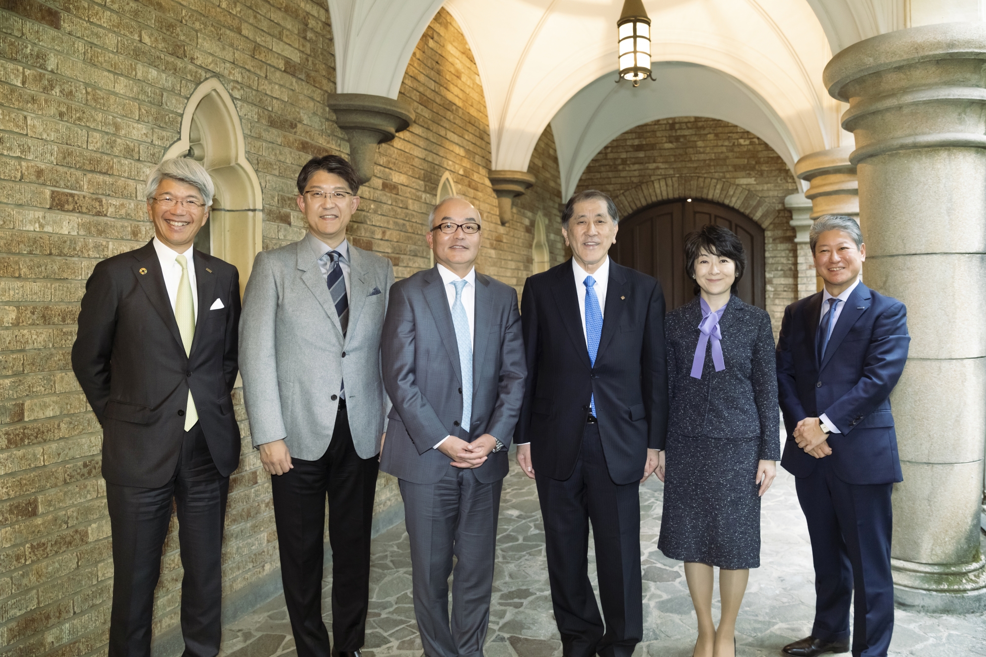 回廊での記念写真：左から藤原理事、佐藤氏、十時氏、田中総長、秋池氏、品田氏